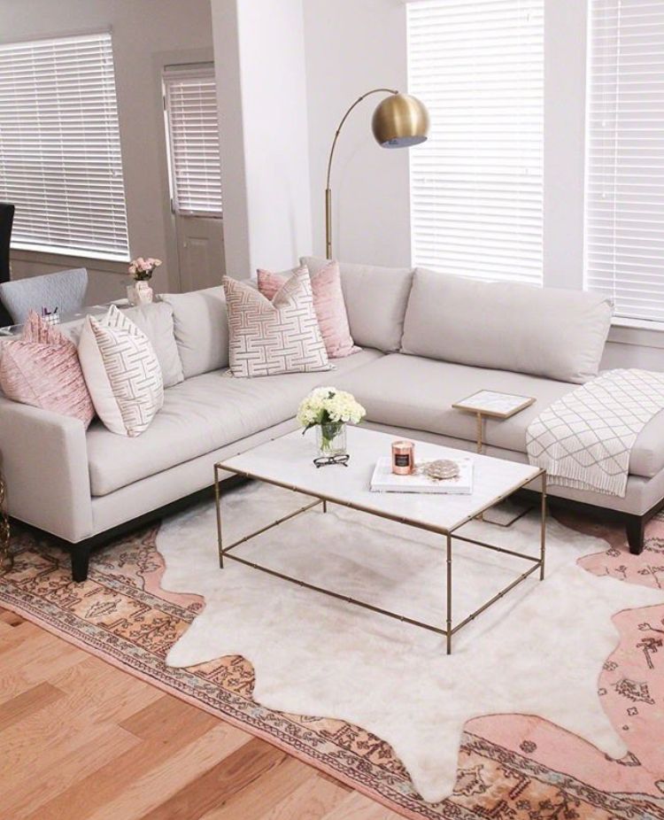 Soft pink and white decor with a vintage rug layered with a white cowhide on top