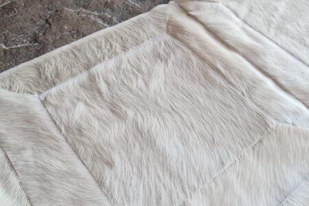 Hair view of a White Hide Patch Cowhide Rug on stone Hair view of a White Hide Patch Cowhide Rug on stone