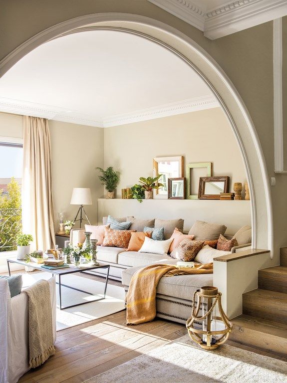 living room with huge arch divider, lots of lighting and salmon cushions