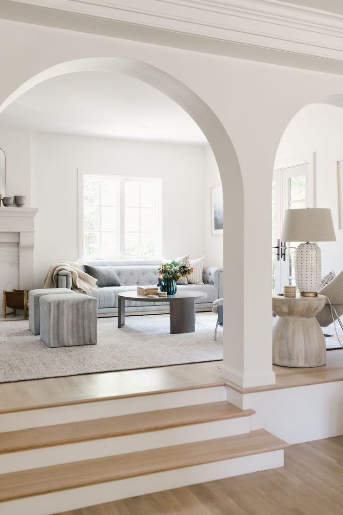 arched room divider with stais leading up to a living room