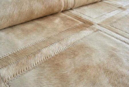 312 Beige Mona Cowhide Rug Detail – Hand-Stitched Patchwork Detail of Beige Mona patchwork cowhide rug showing stitched cowhide squares and texture