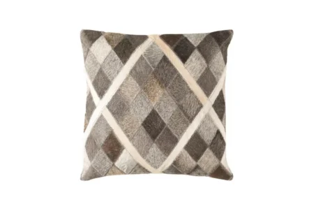 02 0 Lime taupe Cowhide pillow front view Product photograph of a square throw pillow featuring a natural hair-on-cowhide patchwork design. The cushion displays a sophisticated diagonal diamond pattern in varying shades of charcoal grey, taupe, and deep brown. The sections are defined by clean, cream-colored hide bands, creating a sharp, geometric Argyle-style grid.