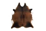 Top-down view of a natural mahogany and dark brown cowhide rug with white patches along the edges