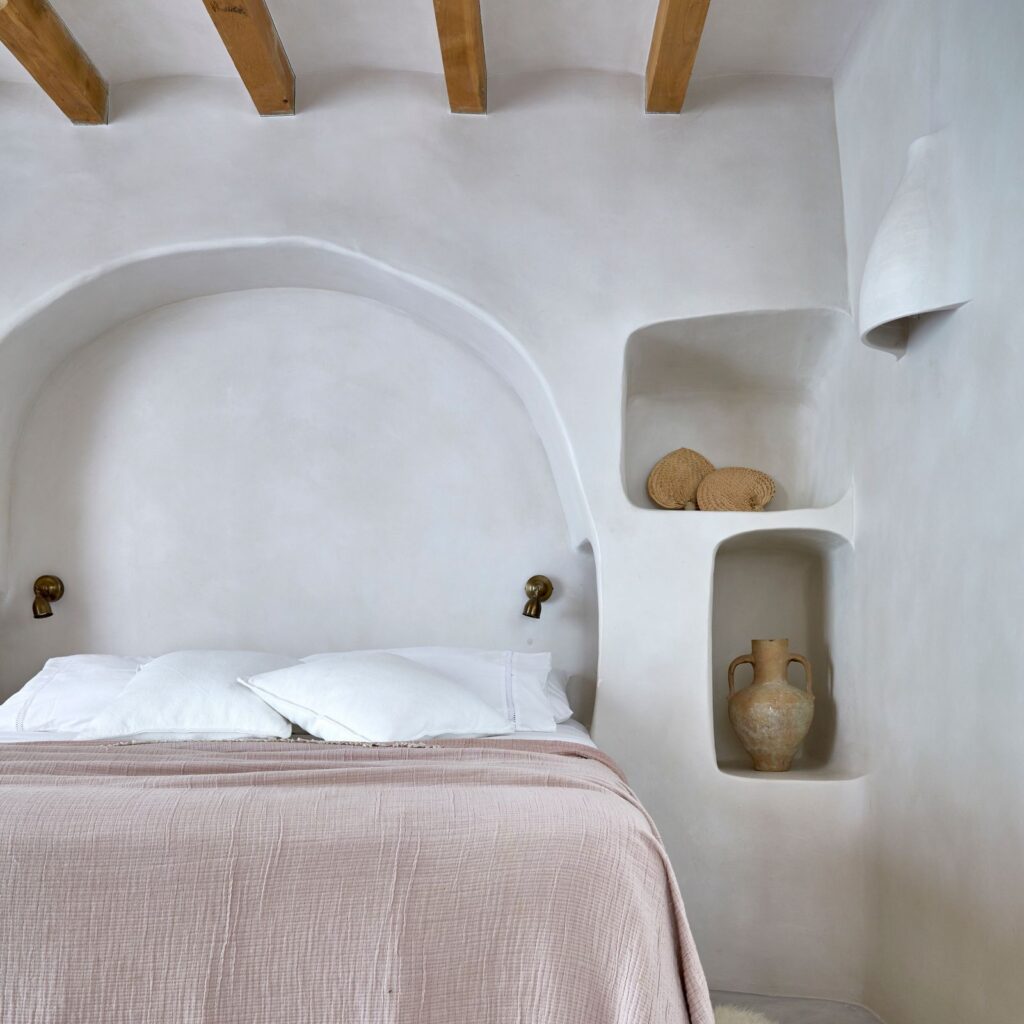White tadelakt for this bedroom, in a very modern Moroccan style, with pink and white linen on the bed